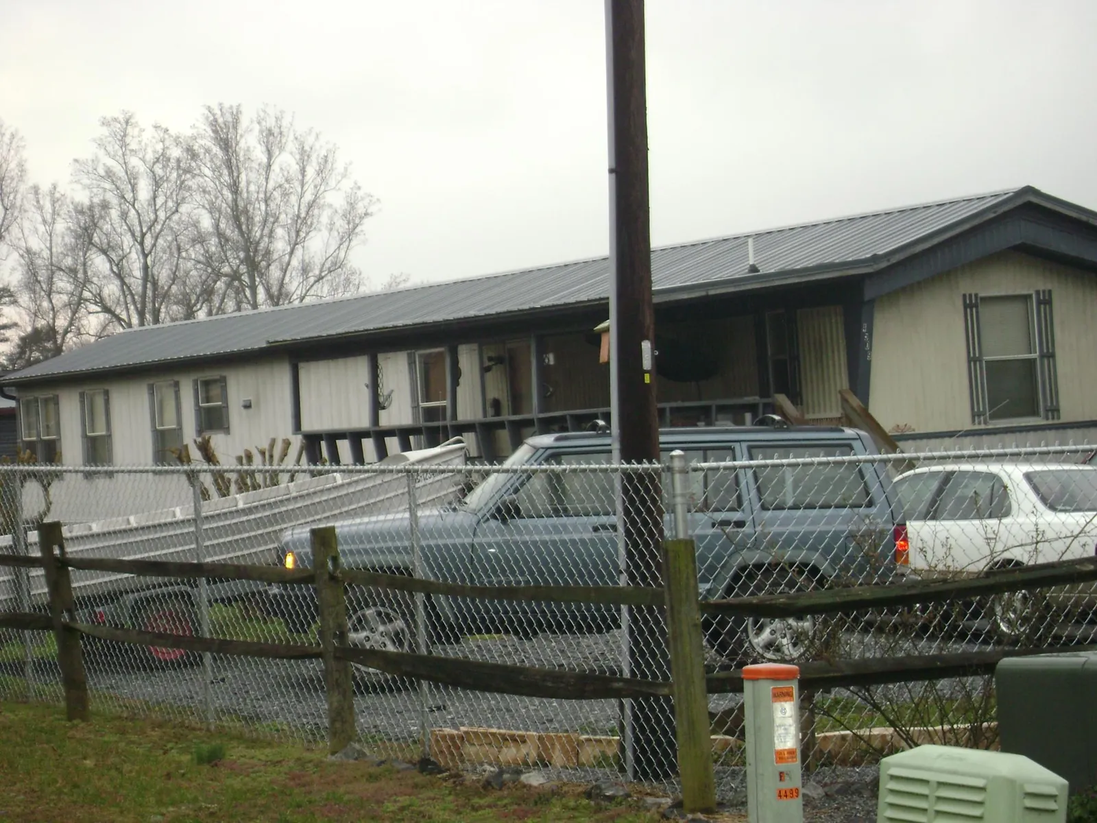 Dark metal roof on a long single story building behind a chain link fence in Acworth
