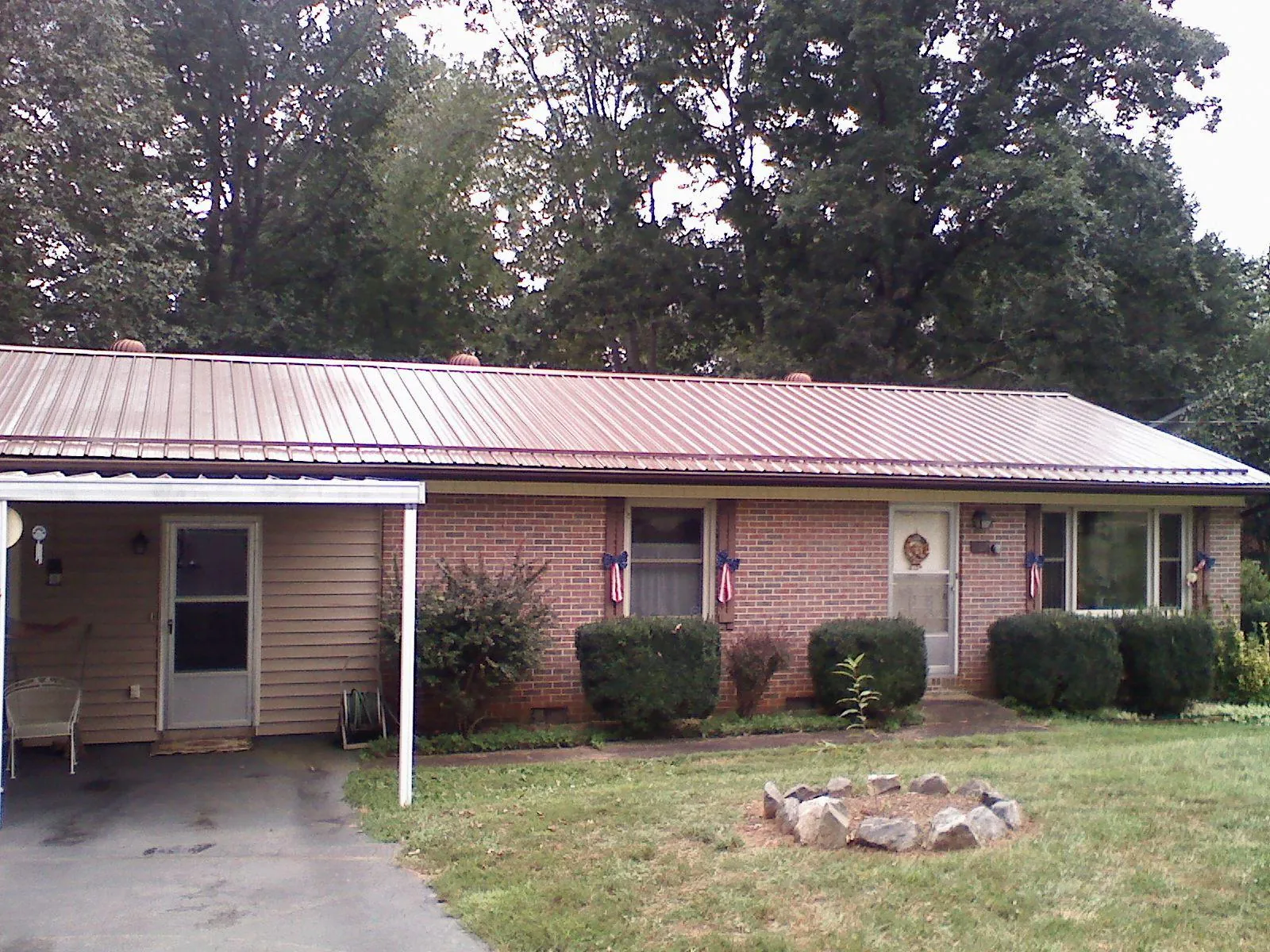 Bronze metal roof and carport on a brick ranch home — Roof Repair work by our crew in Acworth